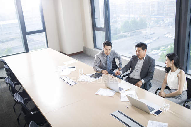 Uomini d'affari che parlano in sala riunioni — Foto stock