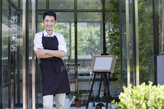 Китайський крамар стояв у дверях кафе — стокове фото