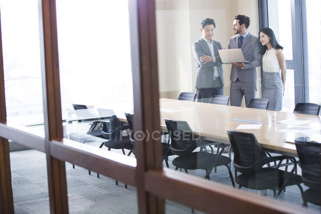 Uomini d'affari che usano il computer portatile in sala riunioni — Foto stock
