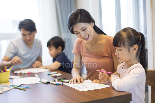 Fratelli cinesi che disegnano con i genitori a casa — Foto stock