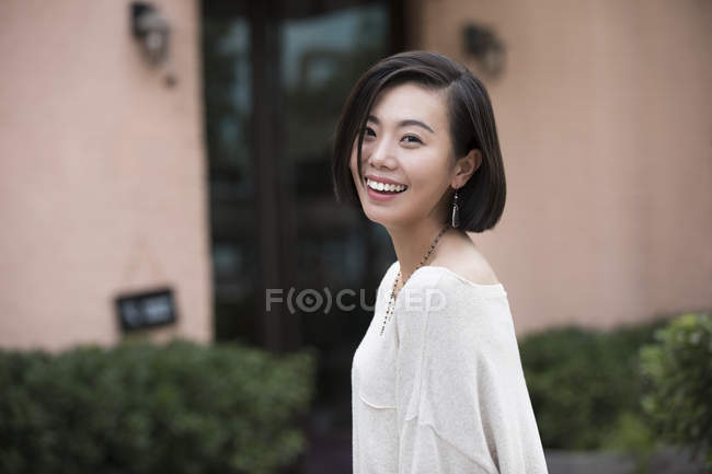 Retrato de una joven china mirando a cámara y riendo - foto de stock