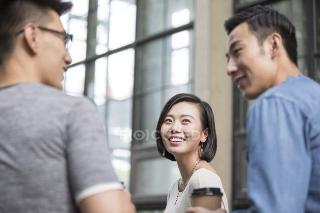 Chinese friends talking in city with coffee — Stock Photo