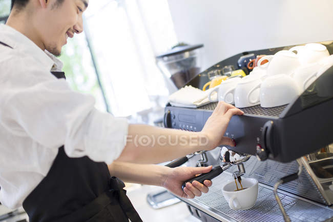 Chinese male barista making coffee — Stock Photo