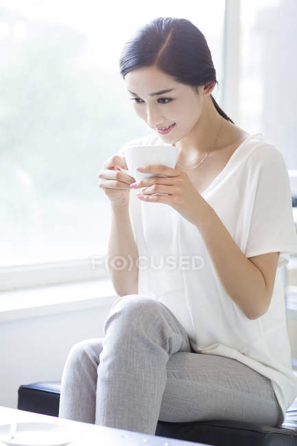 Donna cinese che beve caffè in caffetteria — Foto stock