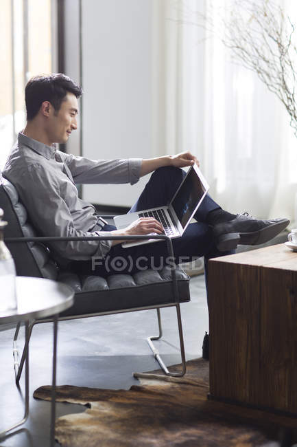 Молодий чоловік працює з ноутбуком в офісі — стокове фото