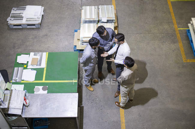 Empresário e engenheiros asiáticos conversando na fábrica — Fotografia de Stock
