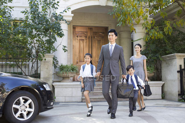 Chino negocio pareja con niños caminando de la mano en la calle - foto de stock