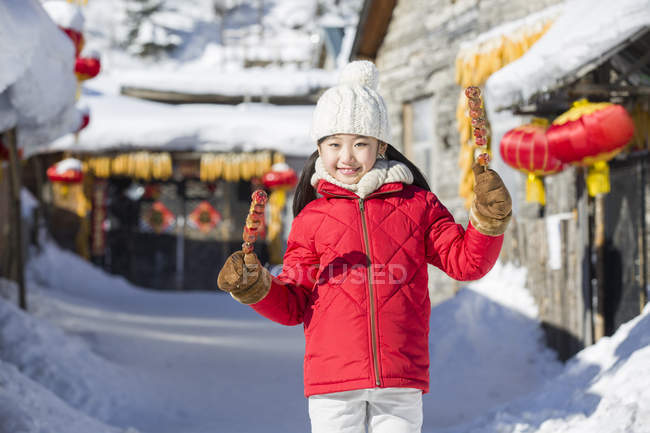 Menina chinesa segurando falcões cristalizados na aldeia festival — Fotografia de Stock