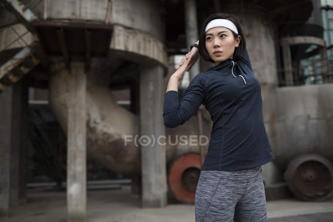 Chinese female athlete stretching on street — Stock Photo