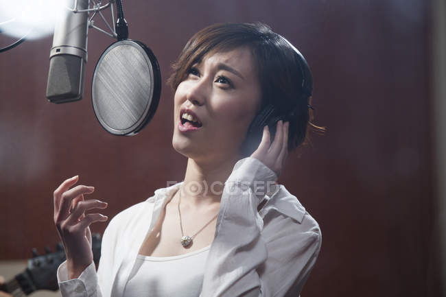 Chinês mulher cantando em estúdio de gravação — Fotografia de Stock