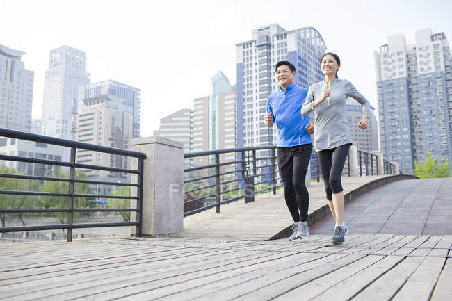 Maduro chino pareja jogging en parque - foto de stock