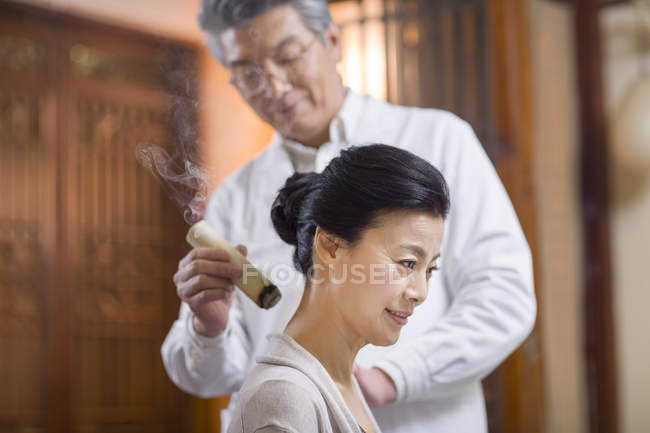 Maduro chino médico dando mujer moxibustión - foto de stock
