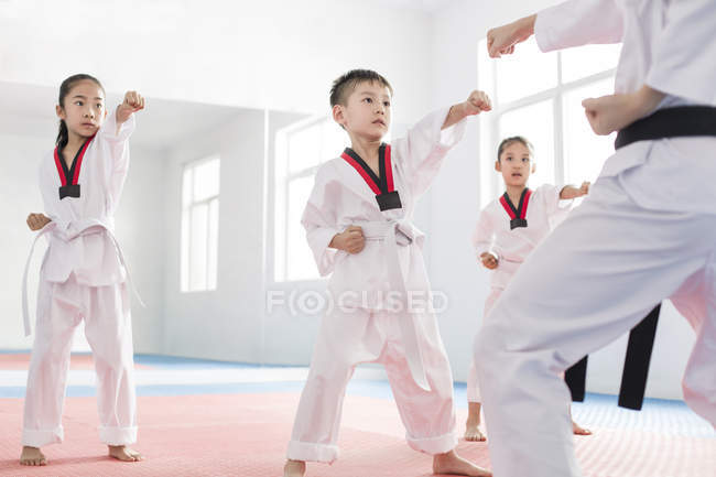 Chinese children practicing Taekwondo stance with instructor — Stock Photo