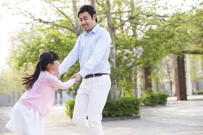 Asiático pai e filha girando ao redor no parque — Fotografia de Stock