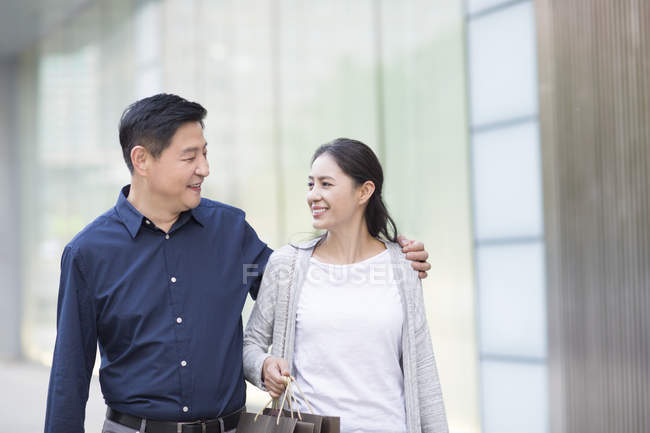 Mature chinese couple walking in city — Stock Photo