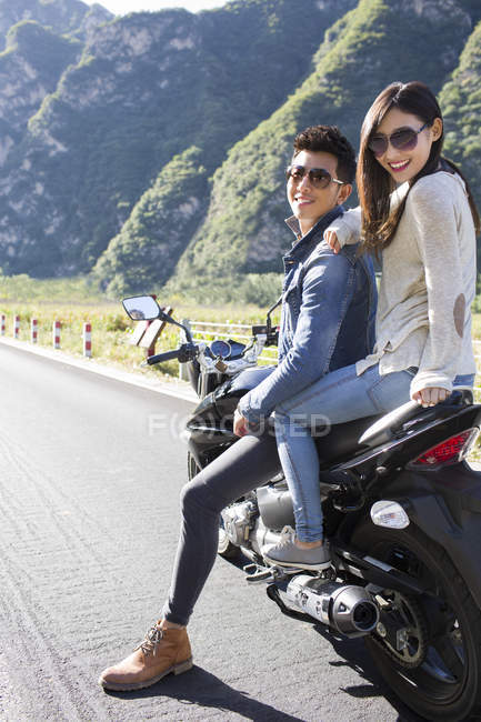 Casal chinês sentado na motocicleta juntos — Fotografia de Stock