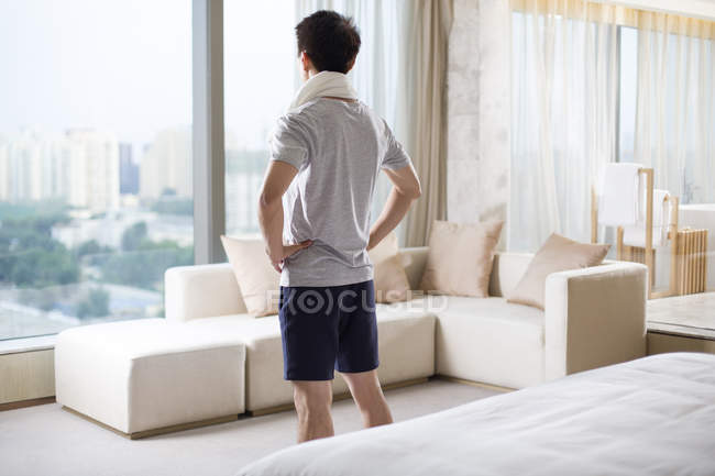 Visão traseira do jovem com toalha em casa — Fotografia de Stock