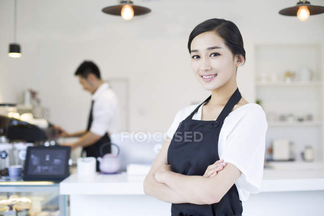 Chinese coffee shop waitress standing with arms crossed — Stock Photo