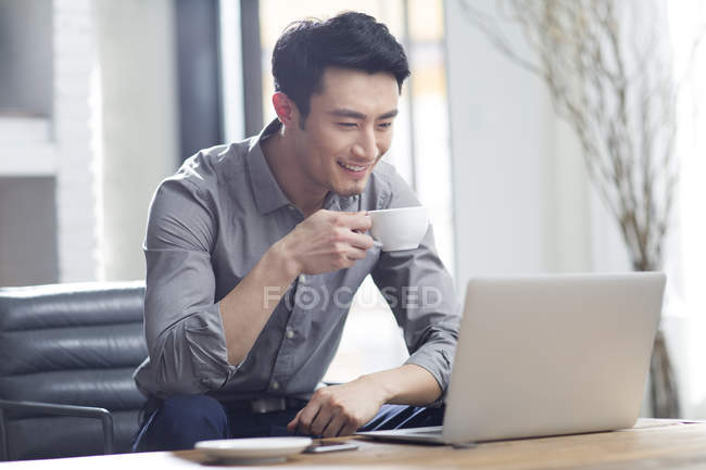 Asiatique homme travaillant avec ordinateur portable dans le bureau — Photo de stock