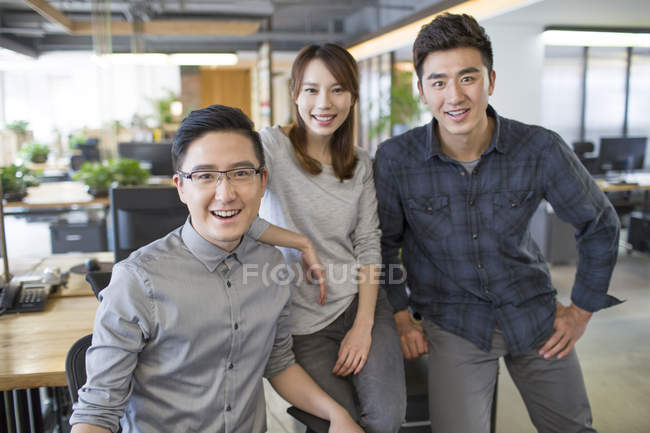 Китайський його працівників, стоячи в офісі — стокове фото