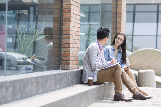 Asian colleagues discussing business on street — Stock Photo