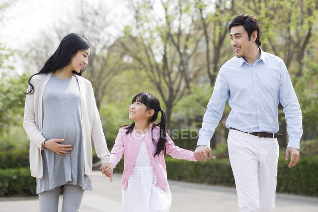 Asiatische Familie hält Händchen beim Spazierengehen im Park — Stockfoto