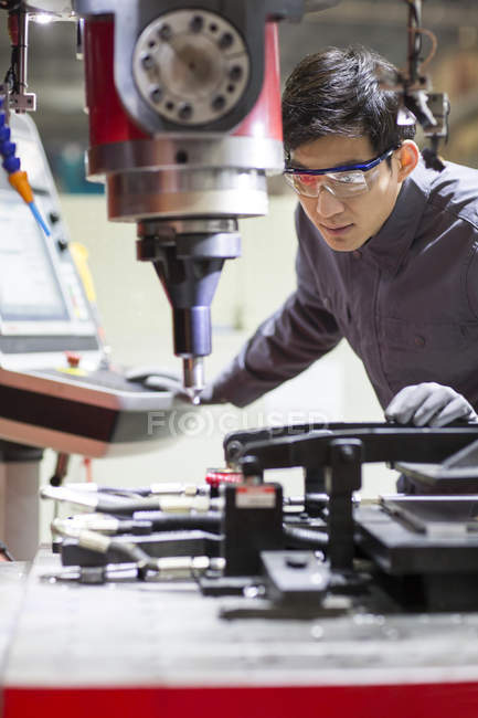 Ingeniero masculino chino que trabaja en fábrica industrial - foto de stock
