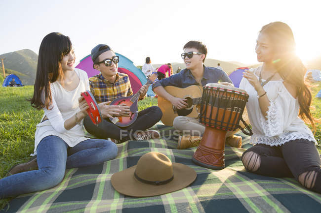 Amigos chinos tocando instrumentos musicales en el festival de música - foto de stock