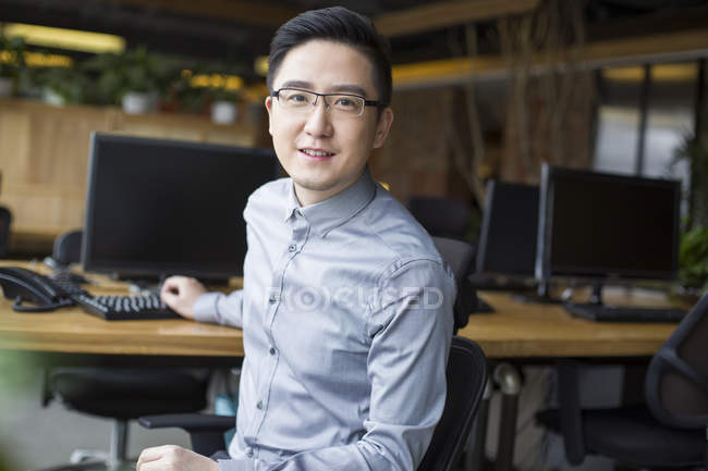 Chinese office worker sitting in office — Stock Photo