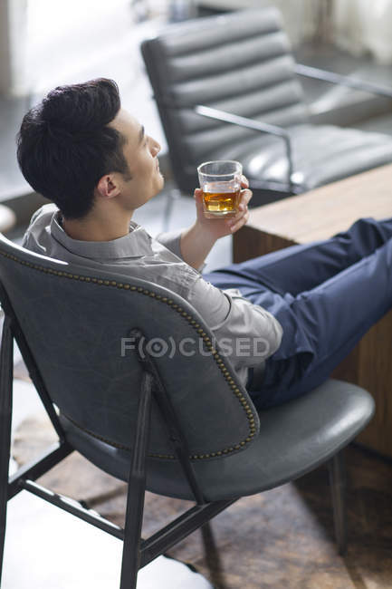 Asiático homem desfrutando bebida alcoólica — Fotografia de Stock