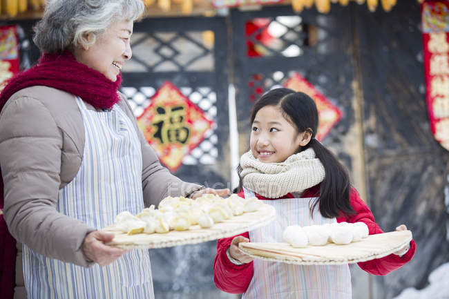 Grandmother and granddaughter holding Chinese dumplings — Stock Photo