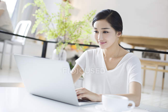 Mulher chinesa usando laptop no café — Fotografia de Stock