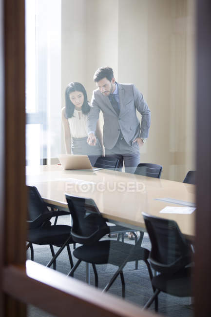 Les hommes d'affaires utilisant un ordinateur portable dans la salle de réunion — Photo de stock
