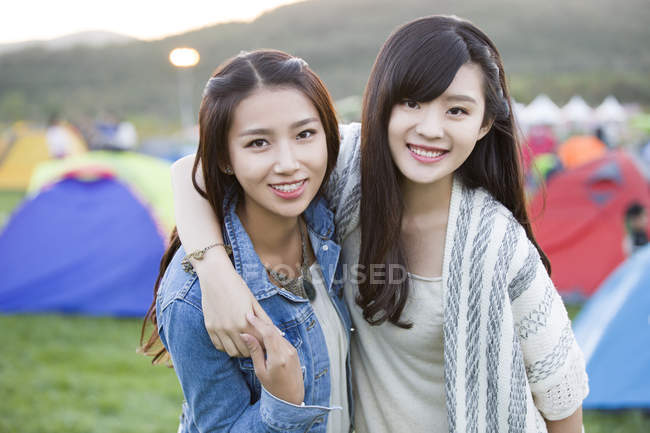 Mujeres chinas abrazándose en el festival de camping - foto de stock