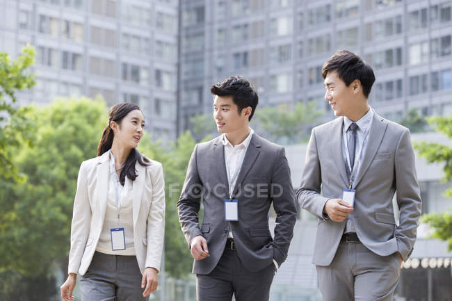 Chinese business people talking on street — Stock Photo