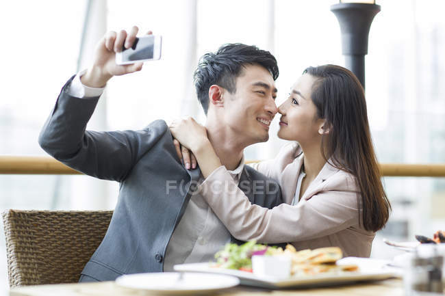 Casal chinês tomando selfie no restaurante — Fotografia de Stock