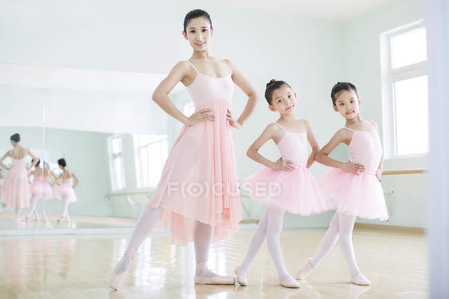Chinesischer Ballettlehrer posiert mit Mädchen im Ballettstudio — Stockfoto
