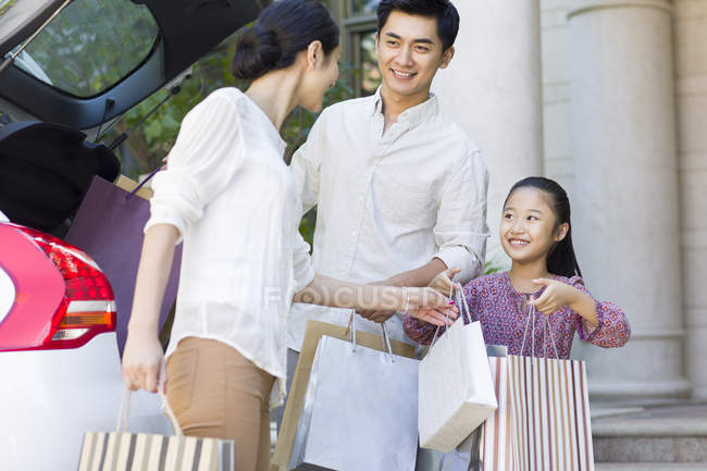 Chinesische Familie holt Einkaufstüten aus dem Kofferraum — Stockfoto