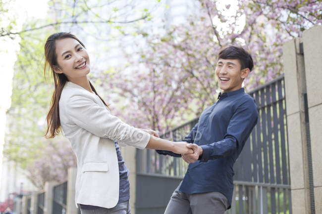 Chinese couple holding hands while spinning — Stock Photo