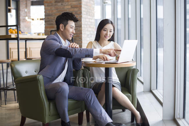 Азіатські чоловік і жінка, які працюють з ноутбуком в кафе — стокове фото