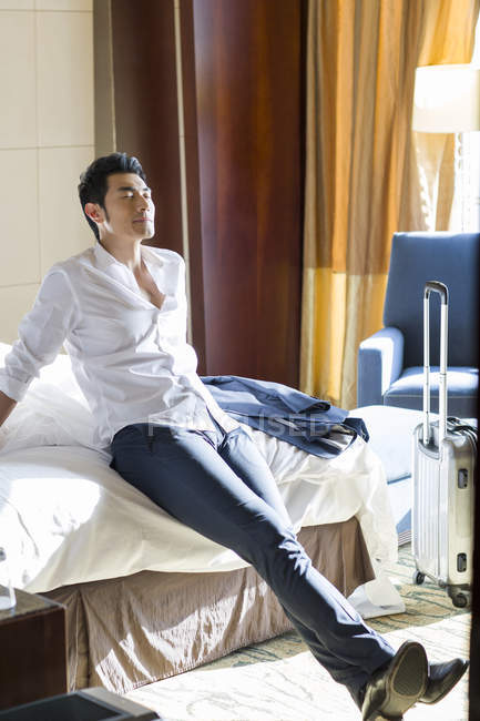 Uomo d'affari cinese che riposa in camera d'albergo — Foto stock