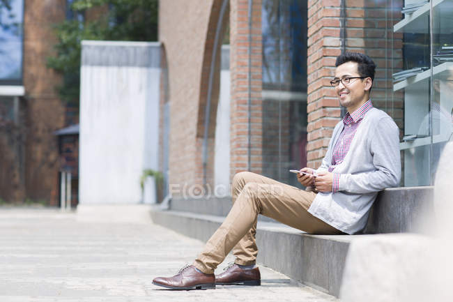 Hombre asiático usando teléfono inteligente en la calle - foto de stock