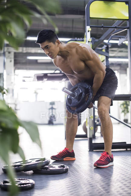 Homme chinois levant haltère à la salle de gym — Photo de stock