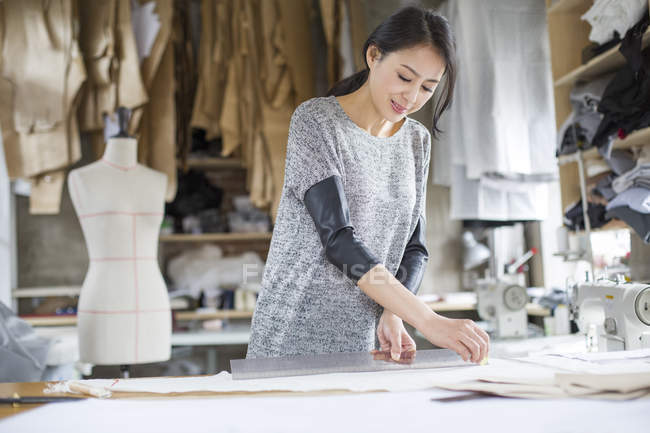 Diseñador de moda chino trabajando en estudio - foto de stock