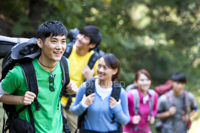 Group of Chinese backpackers hiking in forest — Stock Photo