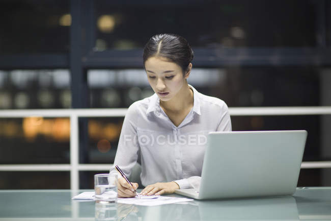 Empresaria china trabajando con documentos en la oficina - foto de stock