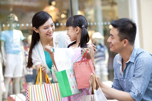 Padres chinos sorprendente hija con regalo en el centro comercial - foto de stock