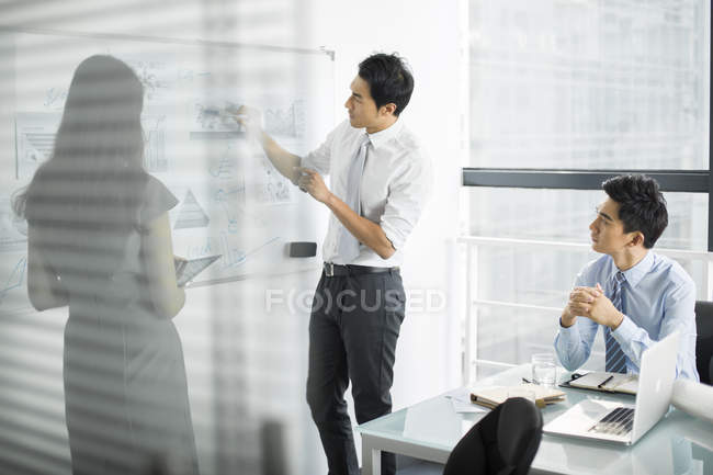 Team di lavoro cinese che parla di riunioni in sala riunioni — Foto stock