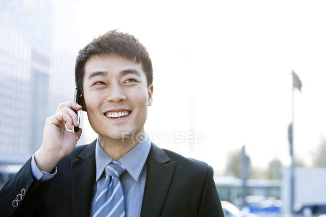 Empresário chinês falando por telefone na rua — Fotografia de Stock