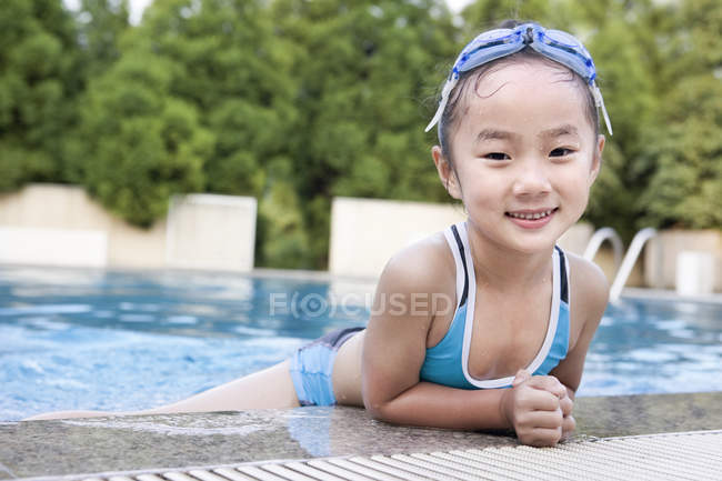 Little Chinese girl in swimwear at swimming pool — Stock Photo